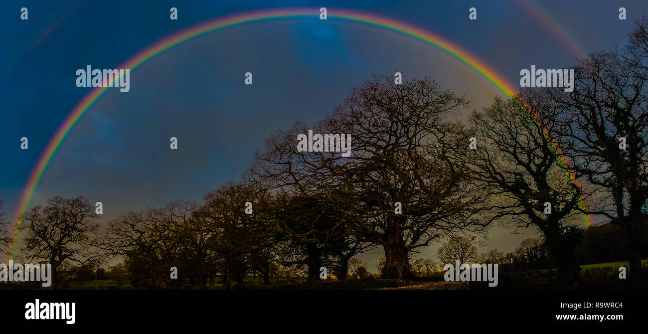 Full rainbow with doubling up over country road. Stock Photo