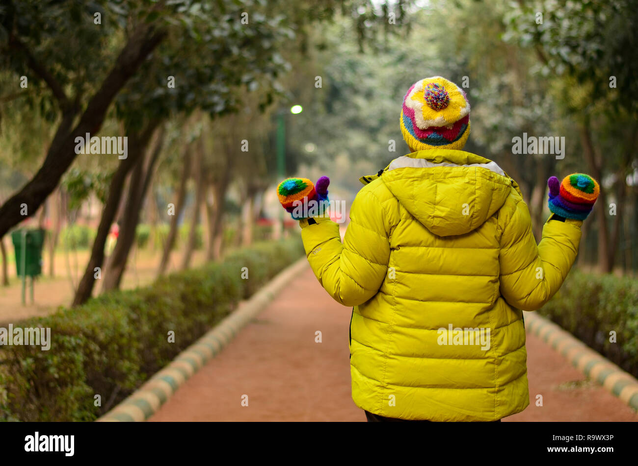 Back shot of a beautiful young Indian woman wearing lime green jacket ...