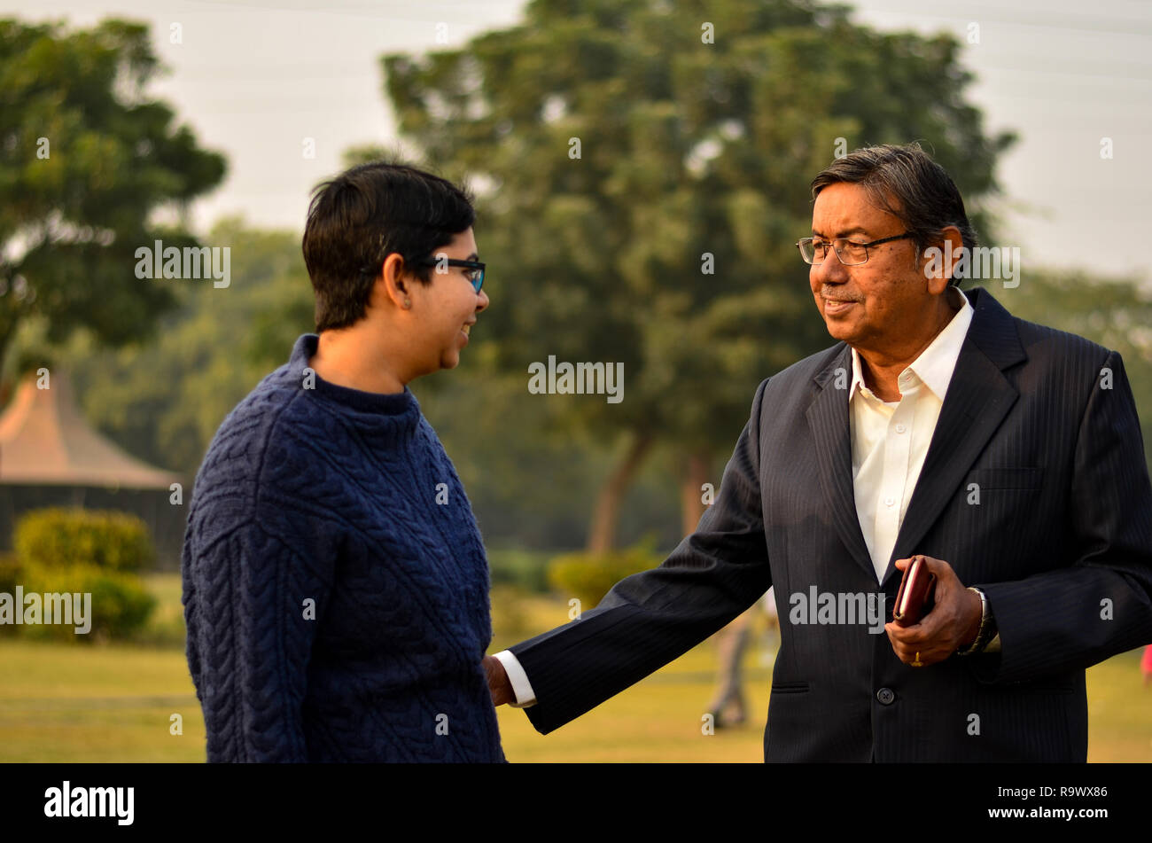 Young Indian woman with short hair speaking smiling with her father in a  park in Delhi, India Stock Photo - Alamy