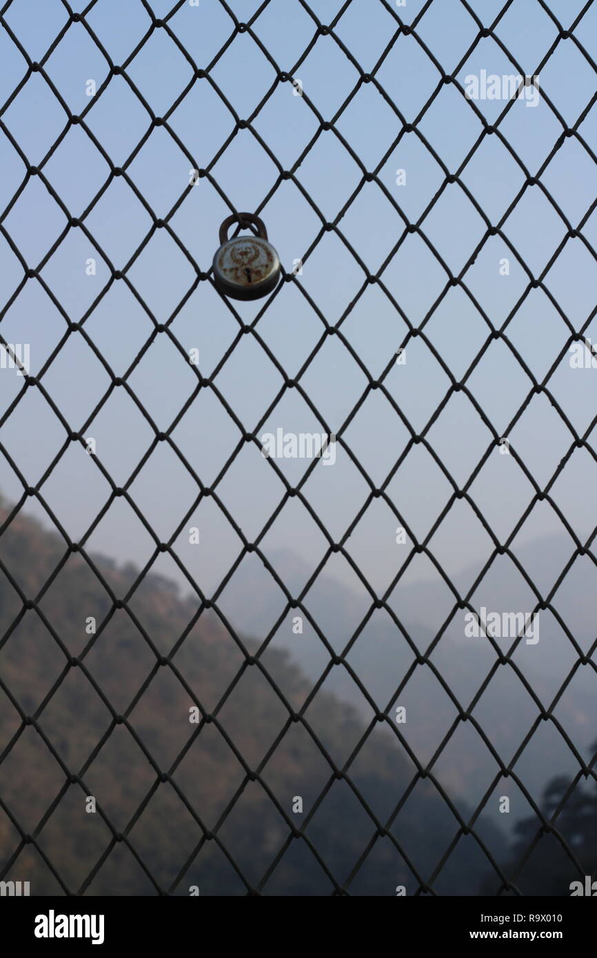 lock on a Metal Wire Mesh Barrier on a Bridge in Pauri Garhwal, Rishikesh, India Stock Photo