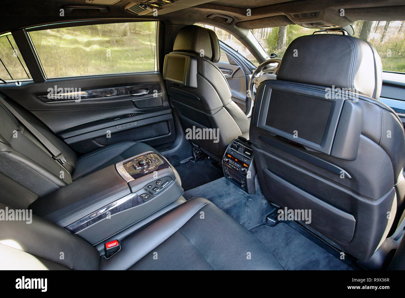 Car inside. Interior of prestige luxury modern car. Two displays for back seats passenger with media control panel copy space and mock up. Stock Photo
