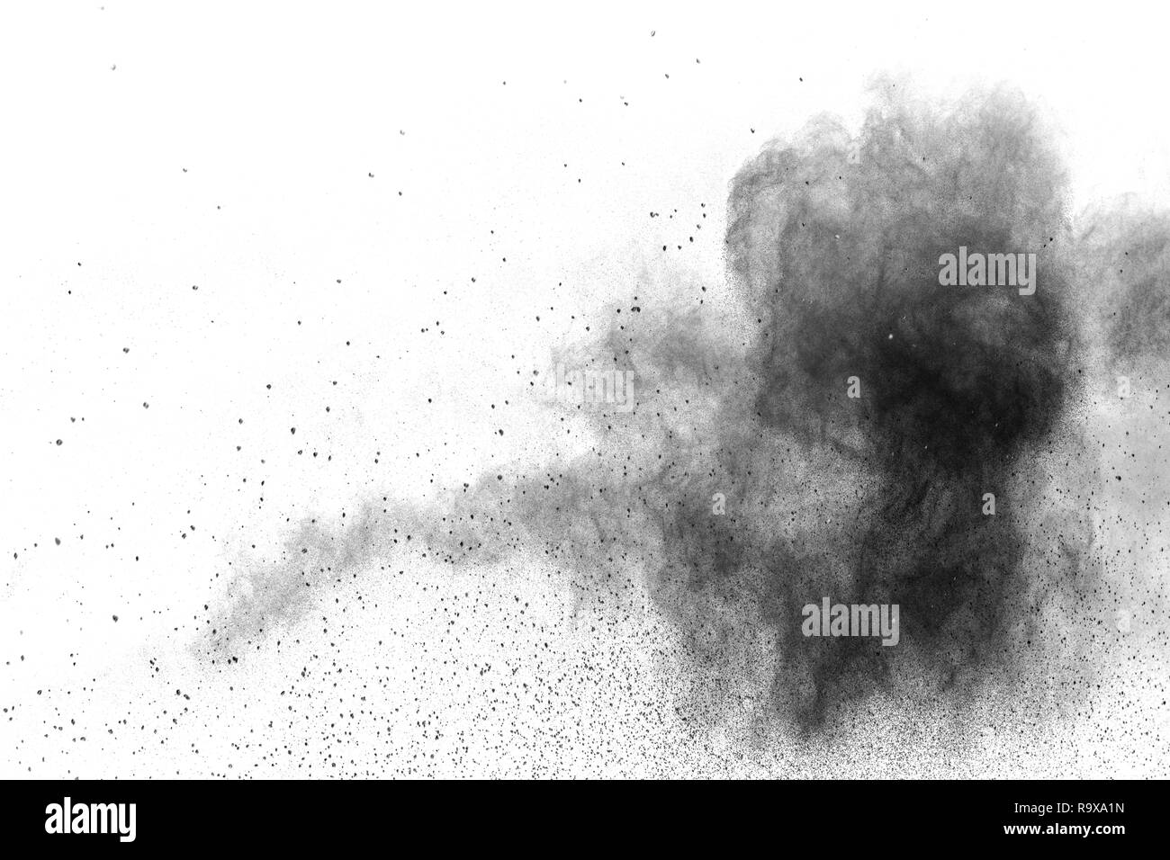 Black particles splattered on white background. Black powder dust splashing. Stock Photo