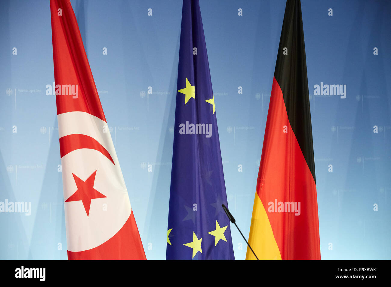 17.10.2018, Berlin, Deutschland -  Die Fahnen von Tunesien, der Europaeischen Union und Deutschlands vor einer Logowand. 00R181017D002 [MODEL RELEASE: Stock Photo