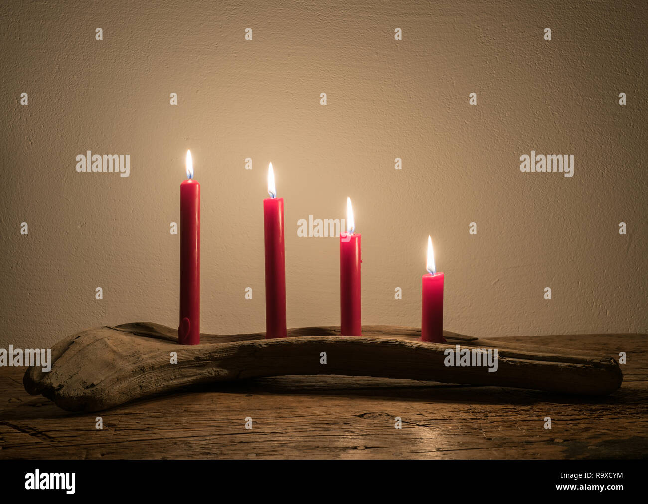 four-red-advent-calendar-candles-burning-bright-in-a-natural-piece-of