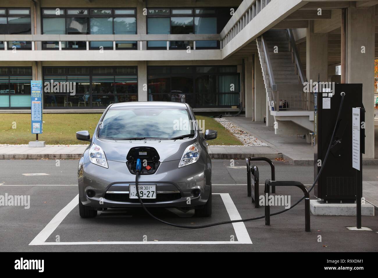 NARA, JAPAN - NOVEMBER 23, 2016: Nissan Leaf electric car charging at a station in Nara, Japan. Zero-emissions vehicles have improved vastly in recent Stock Photo