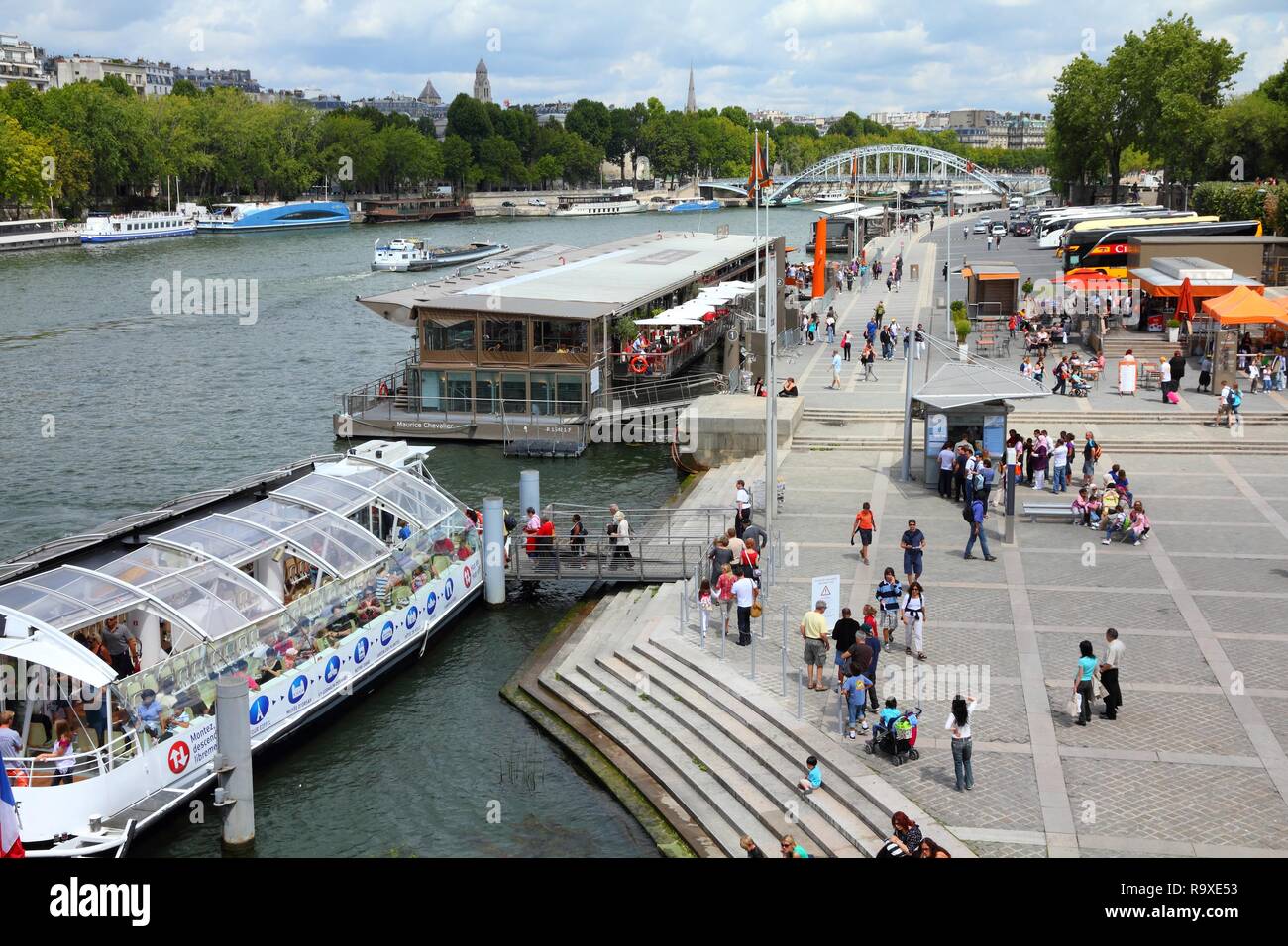 PARIS - JULY 25: Tourists walk along river Seine on July 25, 2011 in Paris, France. Paris is the most visited city in the world with 15.6 million inte Stock Photo