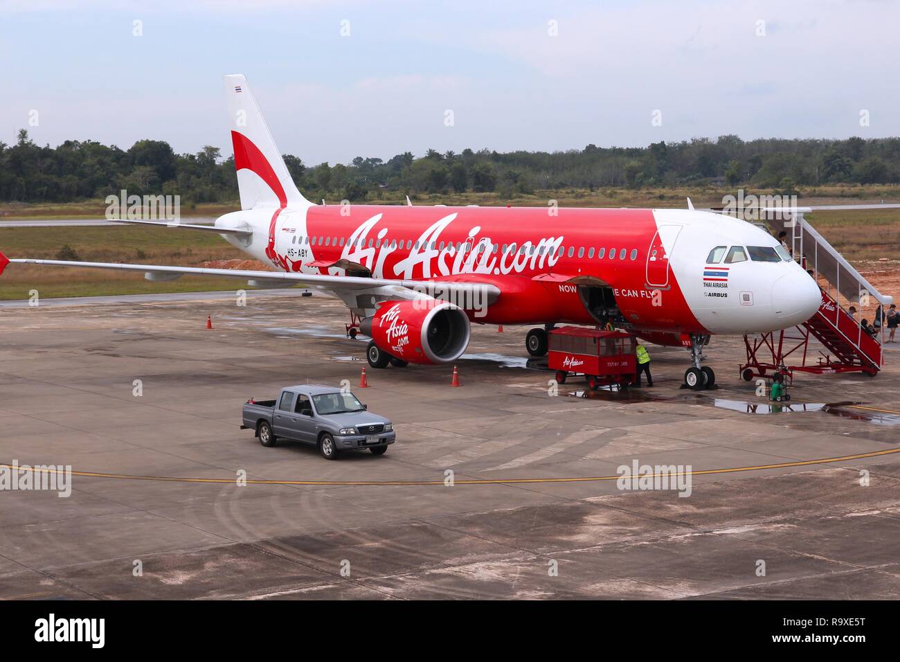 TRANG, THAILAND - DECEMBER 21, 2013: Workers handle Air Asia Airbus A320 at Trang Airport in Thailand. Air Asia group flies 169 aircraft to 121 destin Stock Photo