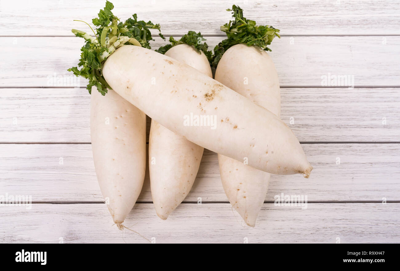 Daikon radish on the white wood background Stock Photo