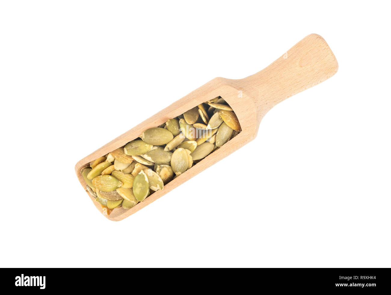 Pumpkin seeds without shell in scoop on white background top view Stock