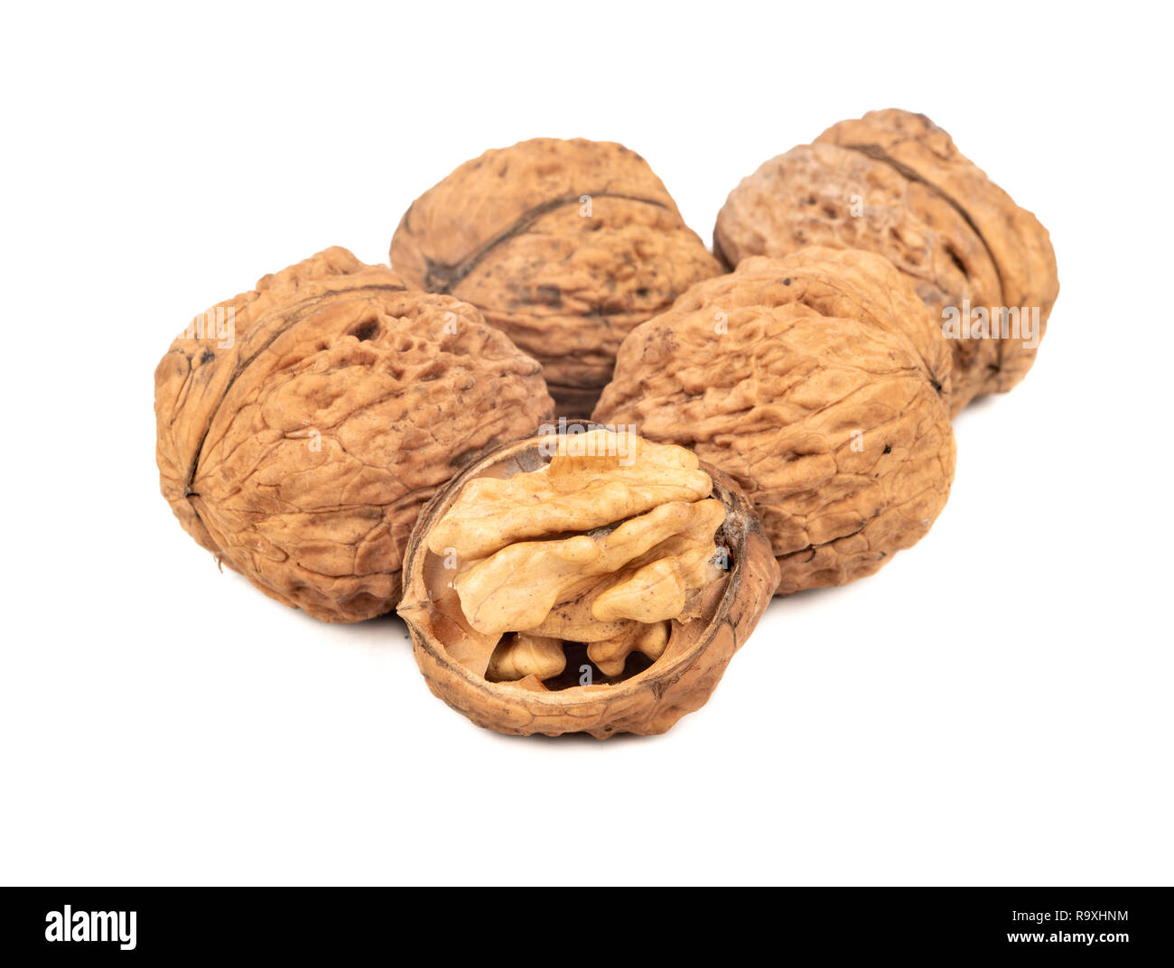 Several large walnuts with a half on a white background Stock Photo