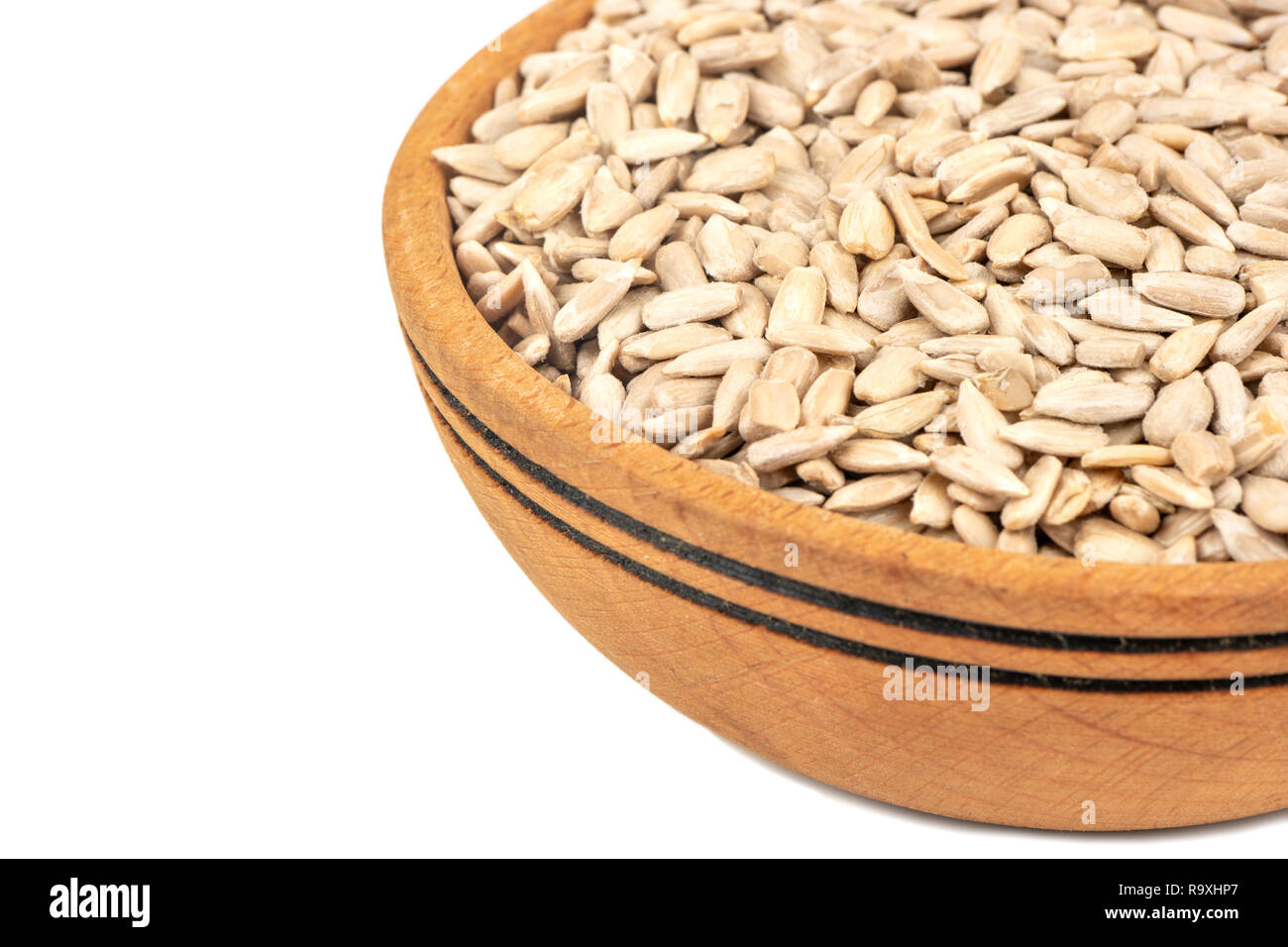 Part of a bowl of sunflower seeds without a shell on a white background