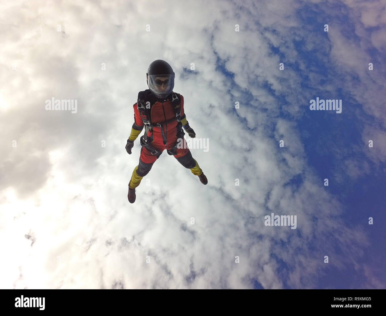 This freefly skydiver is practising some new dive positions in the sky. Thereby the free fall speed is up to 150mph and the jumper has much fun! Stock Photo