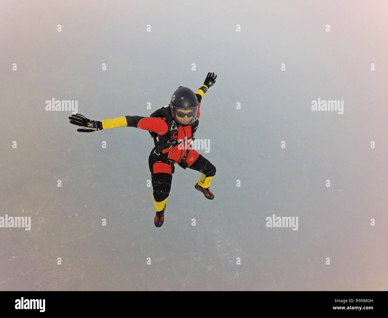 This freefly skydiver is practising some new dive positions in the sky. Thereby the free fall speed is up to 150mph and the jumper has much fun! Stock Photo