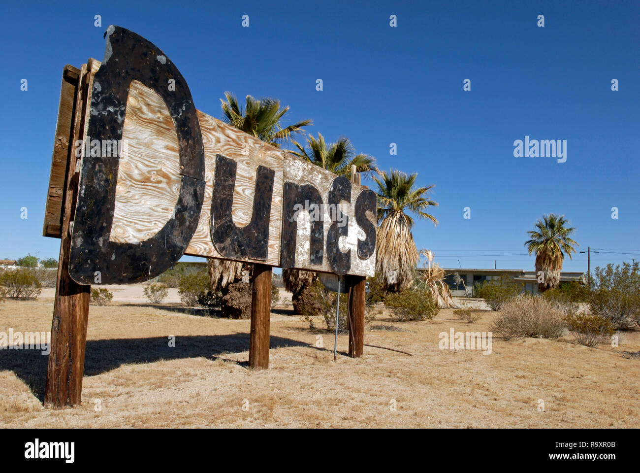A weathered sign advertises the former Dunes motel / apartment complex. The abandoned site stands along historic Route 66 near Barstow, California. Stock Photo