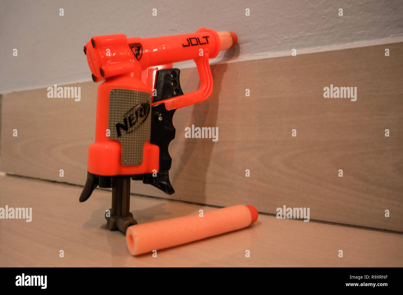 A nerf gun laying against the wall. Stock Photo