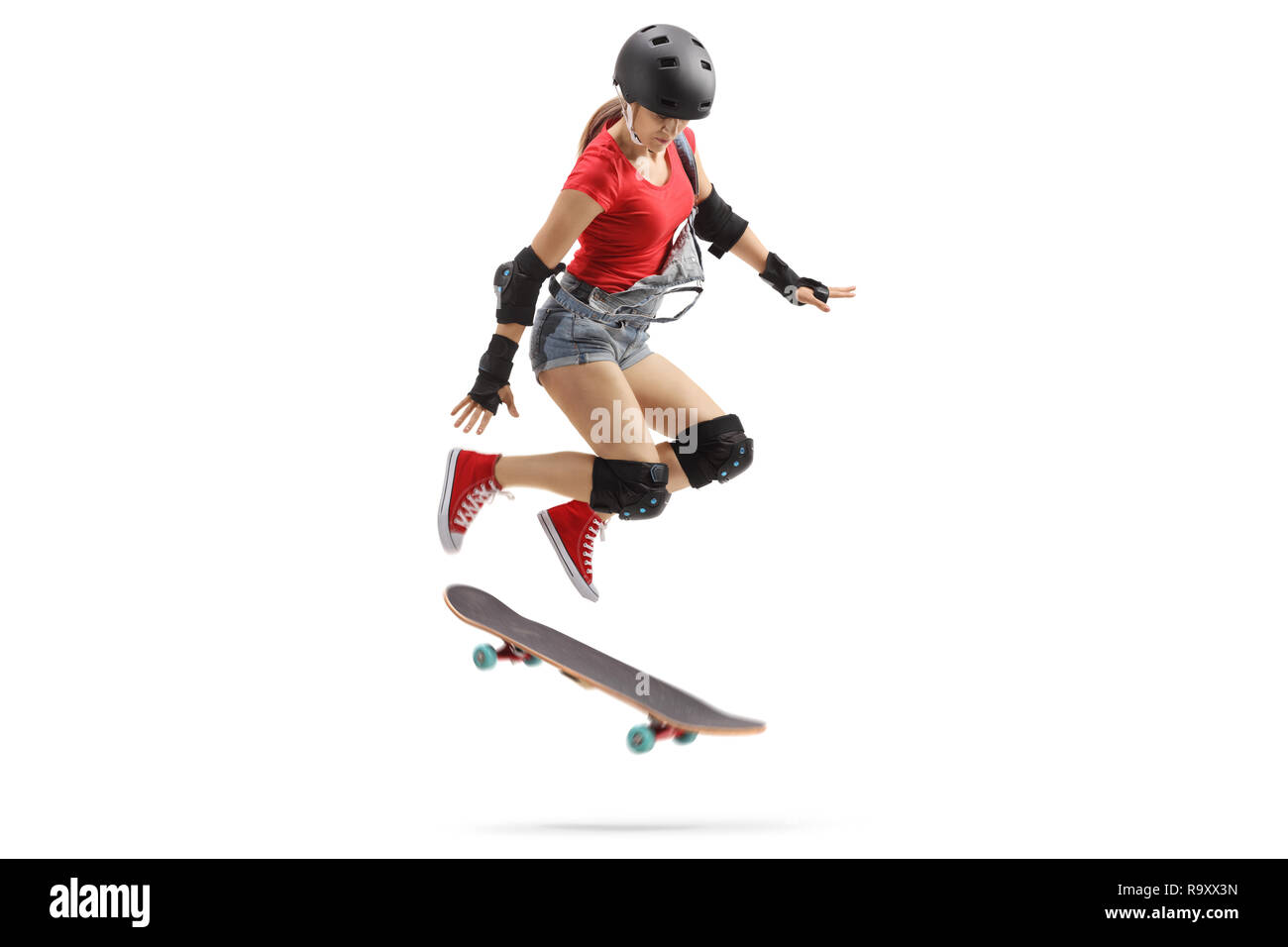 Full length shot of a female jumping with a skateboard isolated on white background Stock Photo