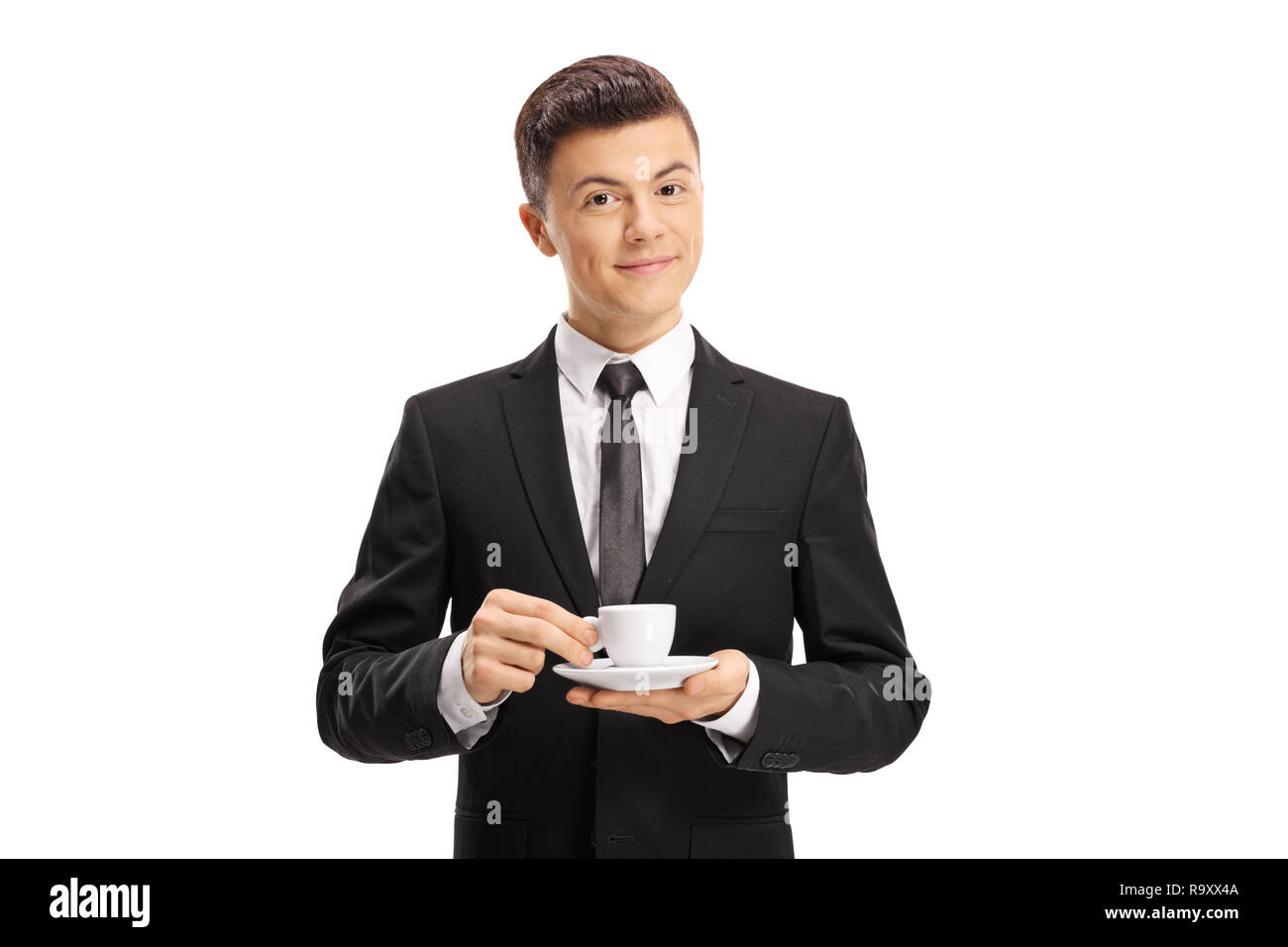 Young man in a suit holding an espresso coffee cup and looking at the ...