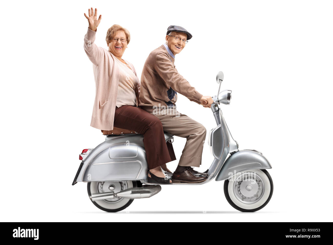 Full length shot of a senior couple riding a vintage scooter and waving isolated on white background Stock Photo