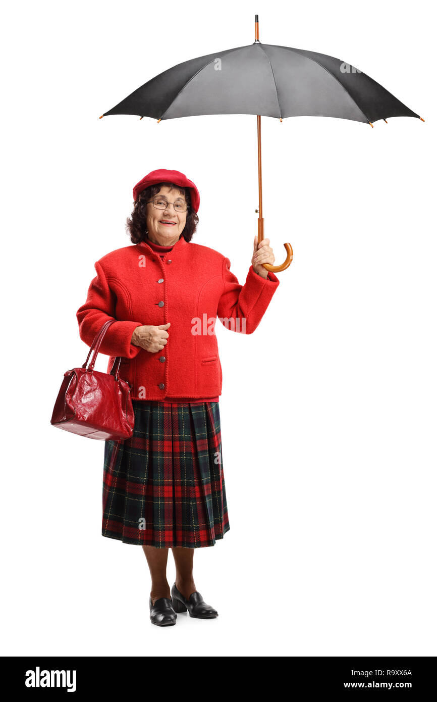 Full length portrait of a senior lady in a red coat holding an umbrella isolated on white background Stock Photo