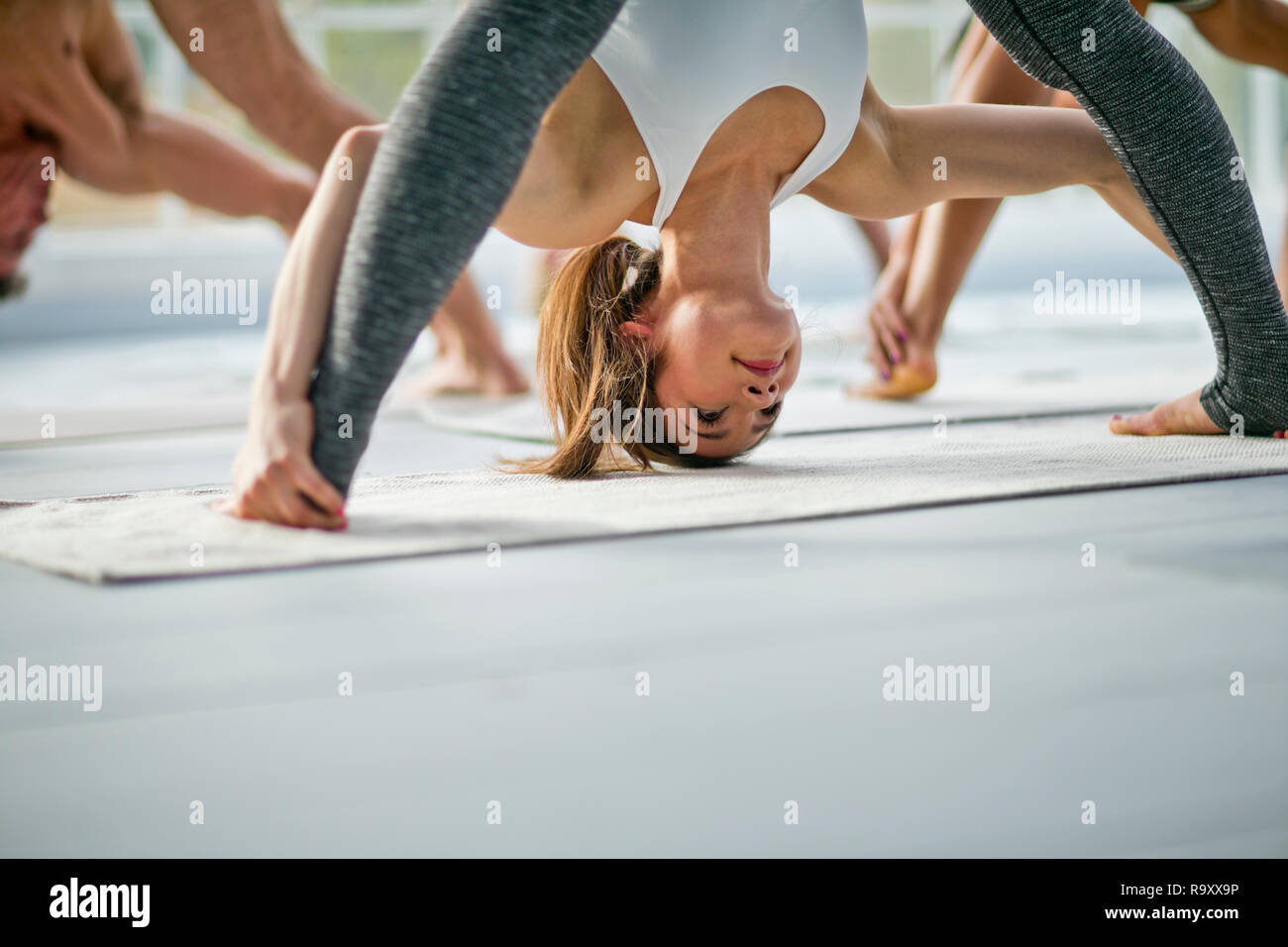 Young woman bending over during a yoga class. Stock Photo