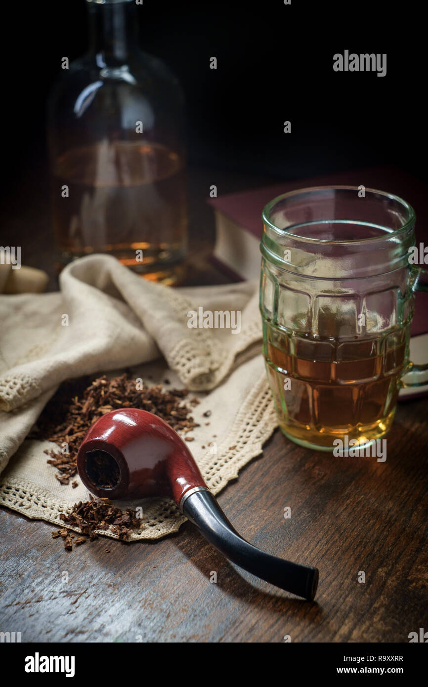 Leisure tobacco pipe and whisky with bottle and a good mystery book Stock Photo