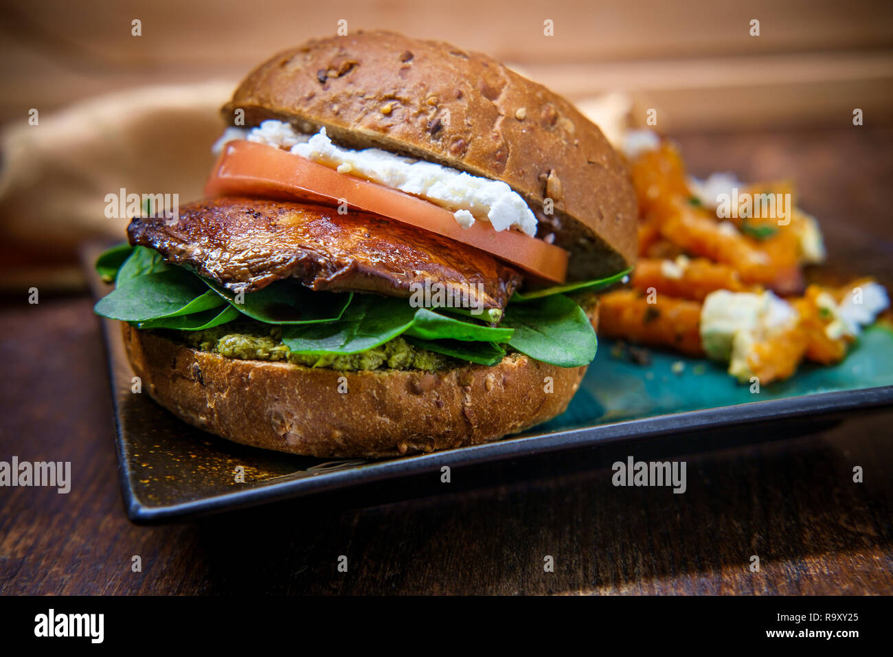 Portobello mushroom sandwich with goat cheese pesto and side of Greek sweet potato fries Stock