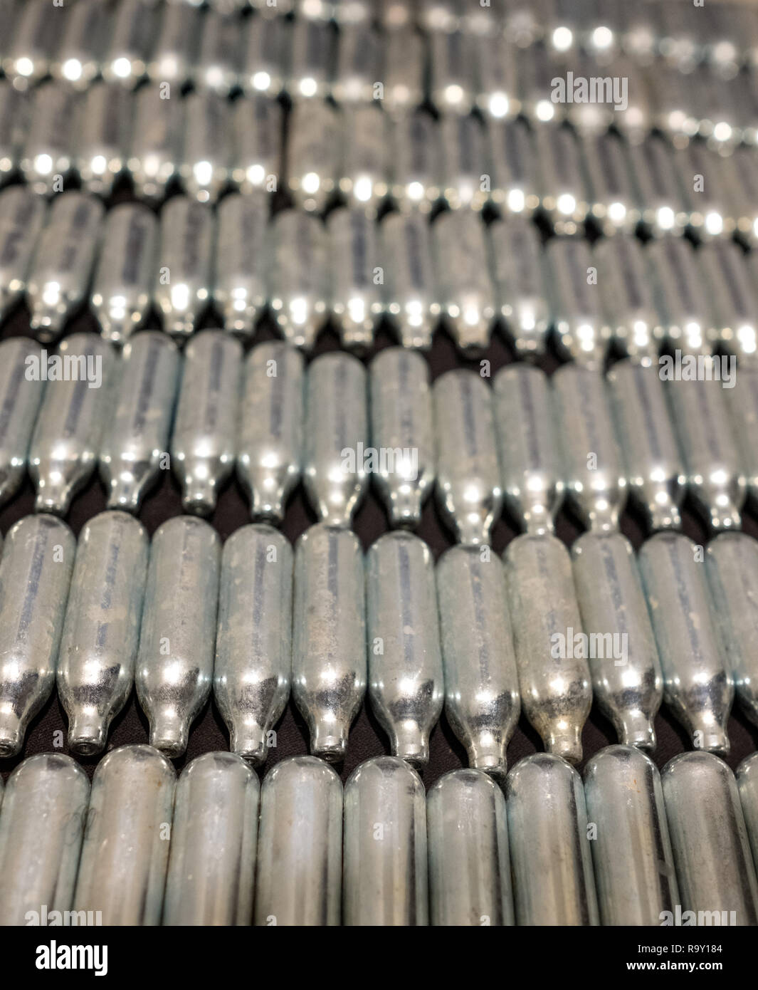 Rows of old rusty nitrous oxide cannisters / cream puff chargers the