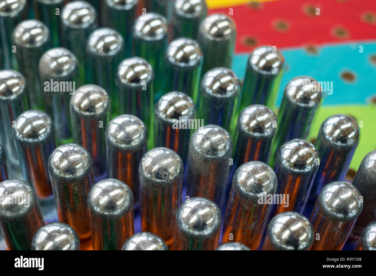 Empty nitrous oxide cannisters reflecting psychedelic colours the metal cylinders contain