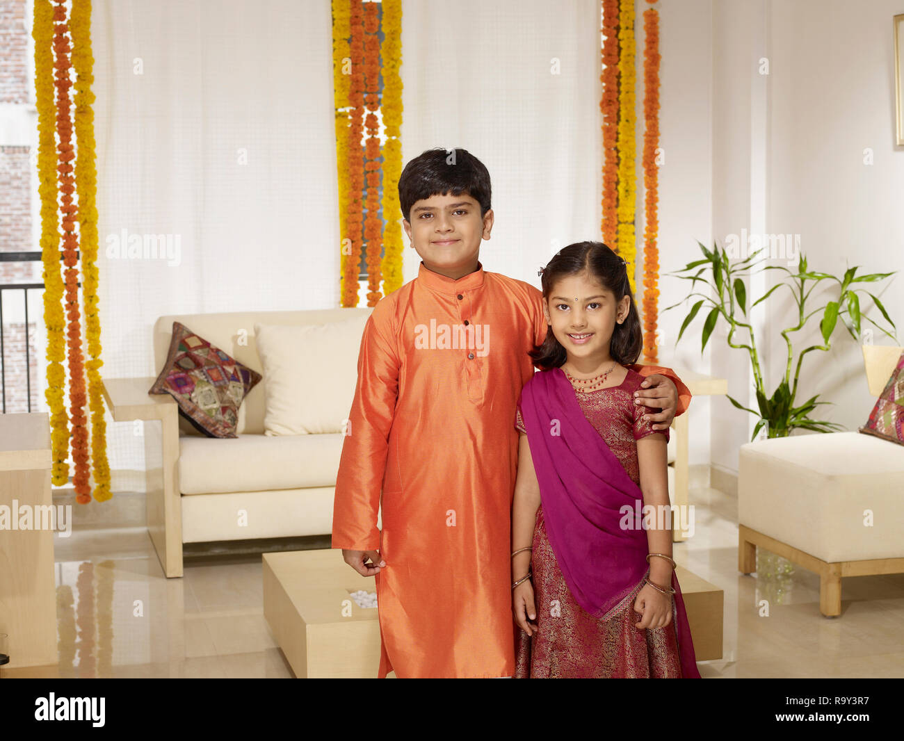 PORTRAIT OF INDIAN GIRL AND HER BROTHER DRESSED IN FORMAL CLOTHES ON A FESTIVE DAY Stock Photo