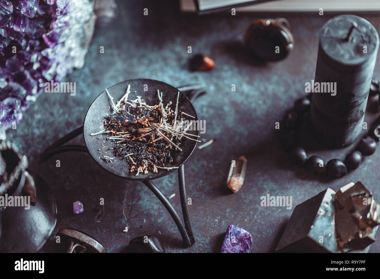 Burning herbs on a witch's altar for a magical ritual among crystals and  black candles Stock Photo - Alamy