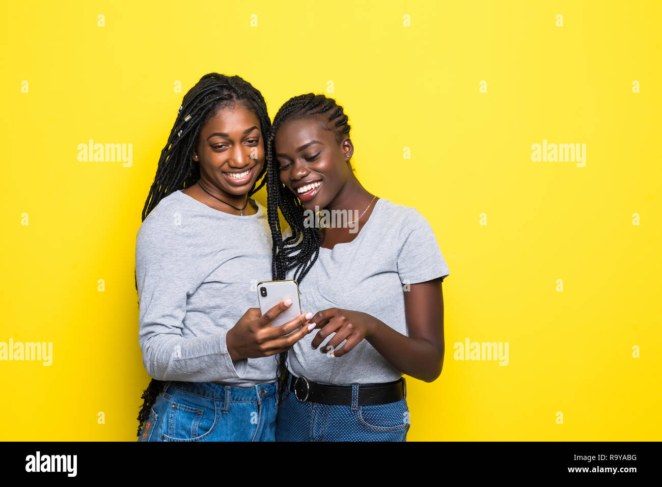 Two african women expressing excitement or surprise while both using ...