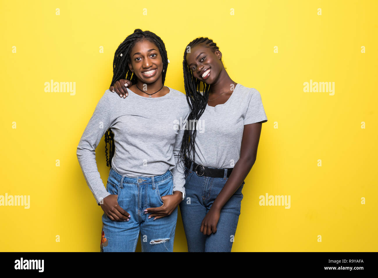 Portrait of two young african women standing together isolated over ...