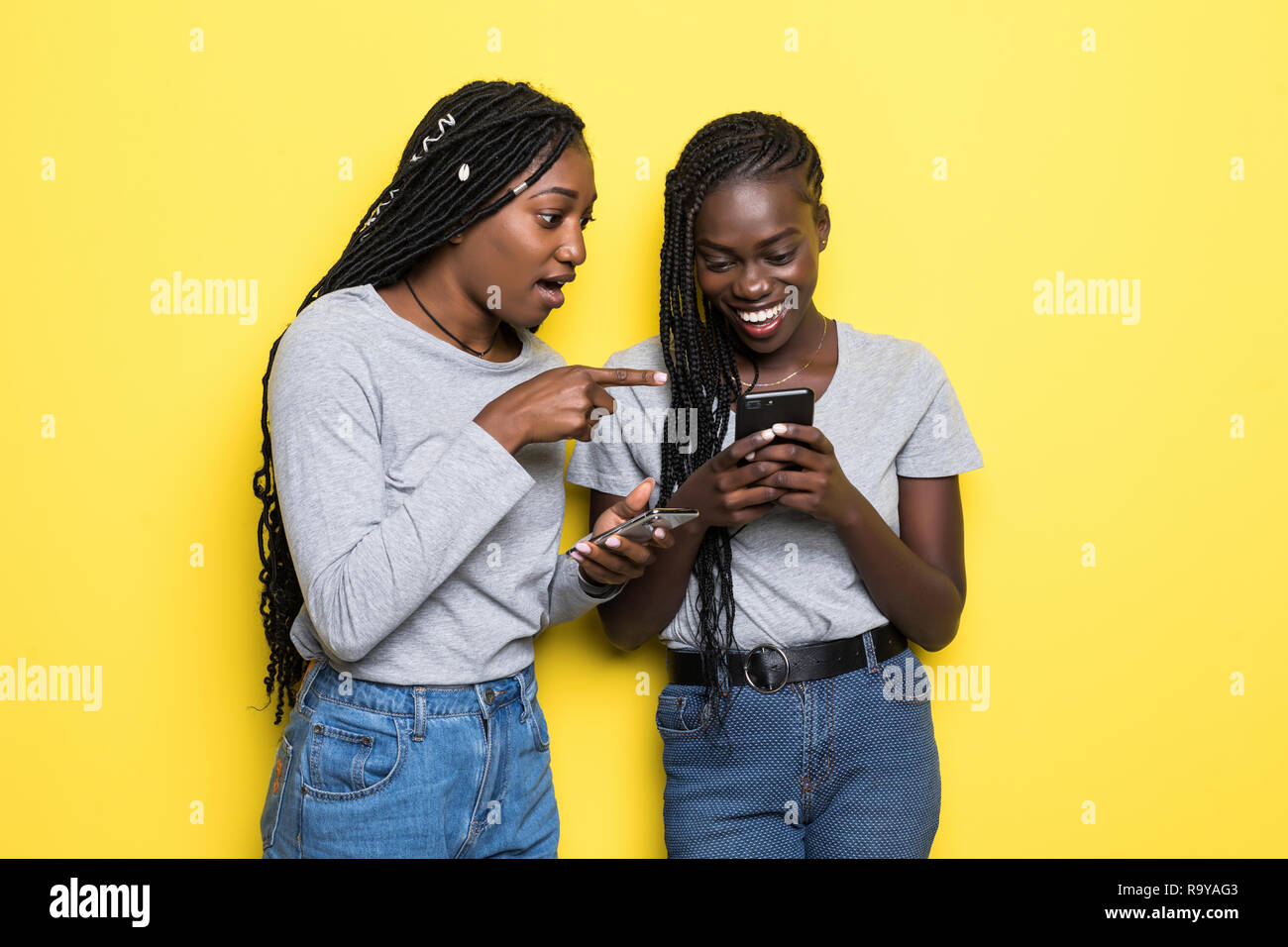 Two african women expressing excitement or surprise while both using ...