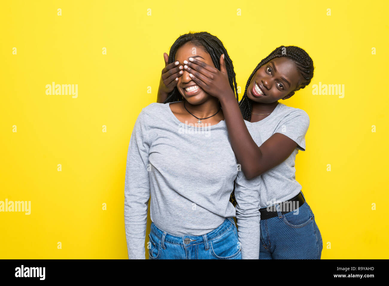 Portrait of two young african women make surprise and cover eyes on ...