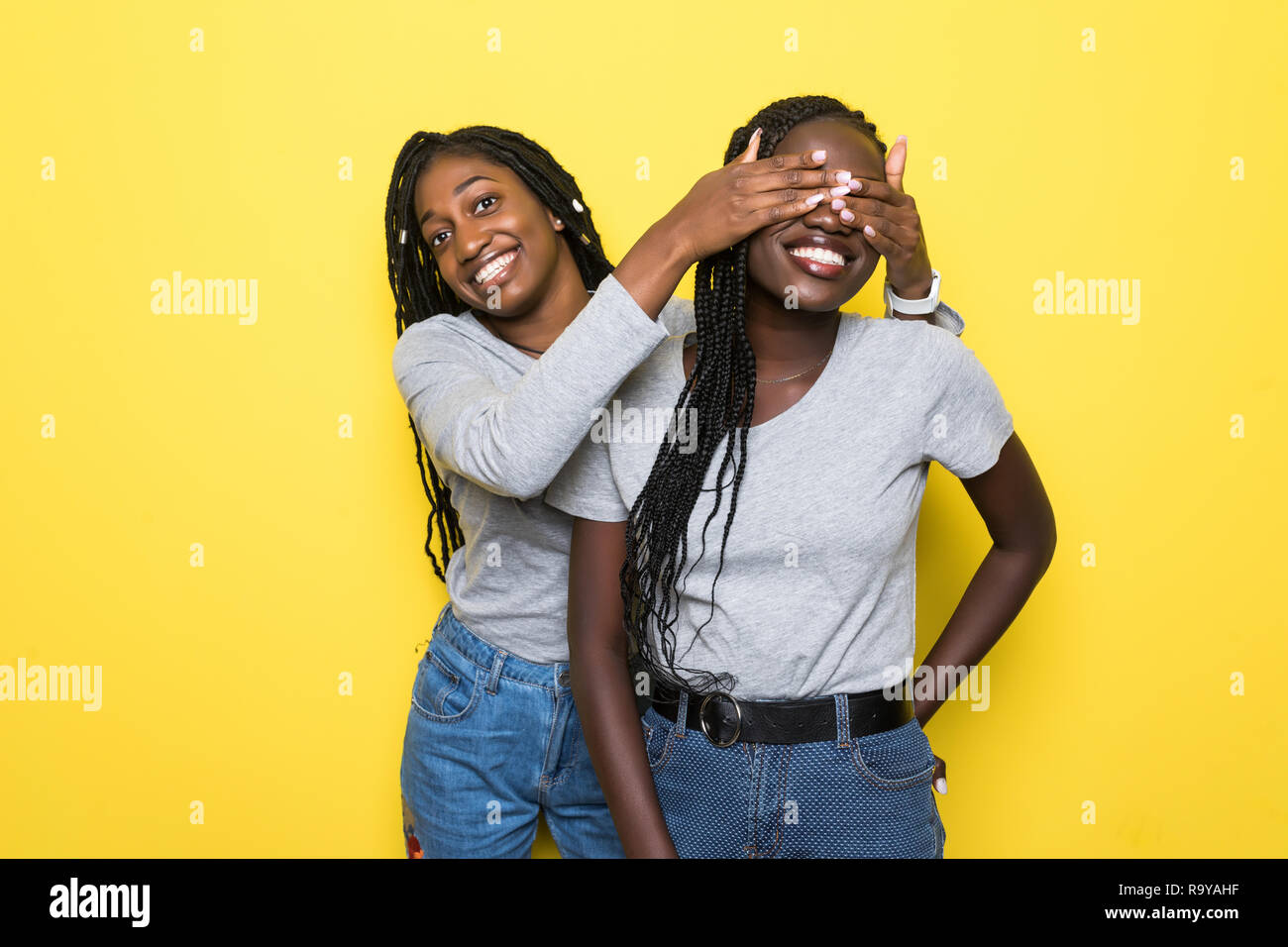 Portrait of two young african women make surprise and cover eyes on ...