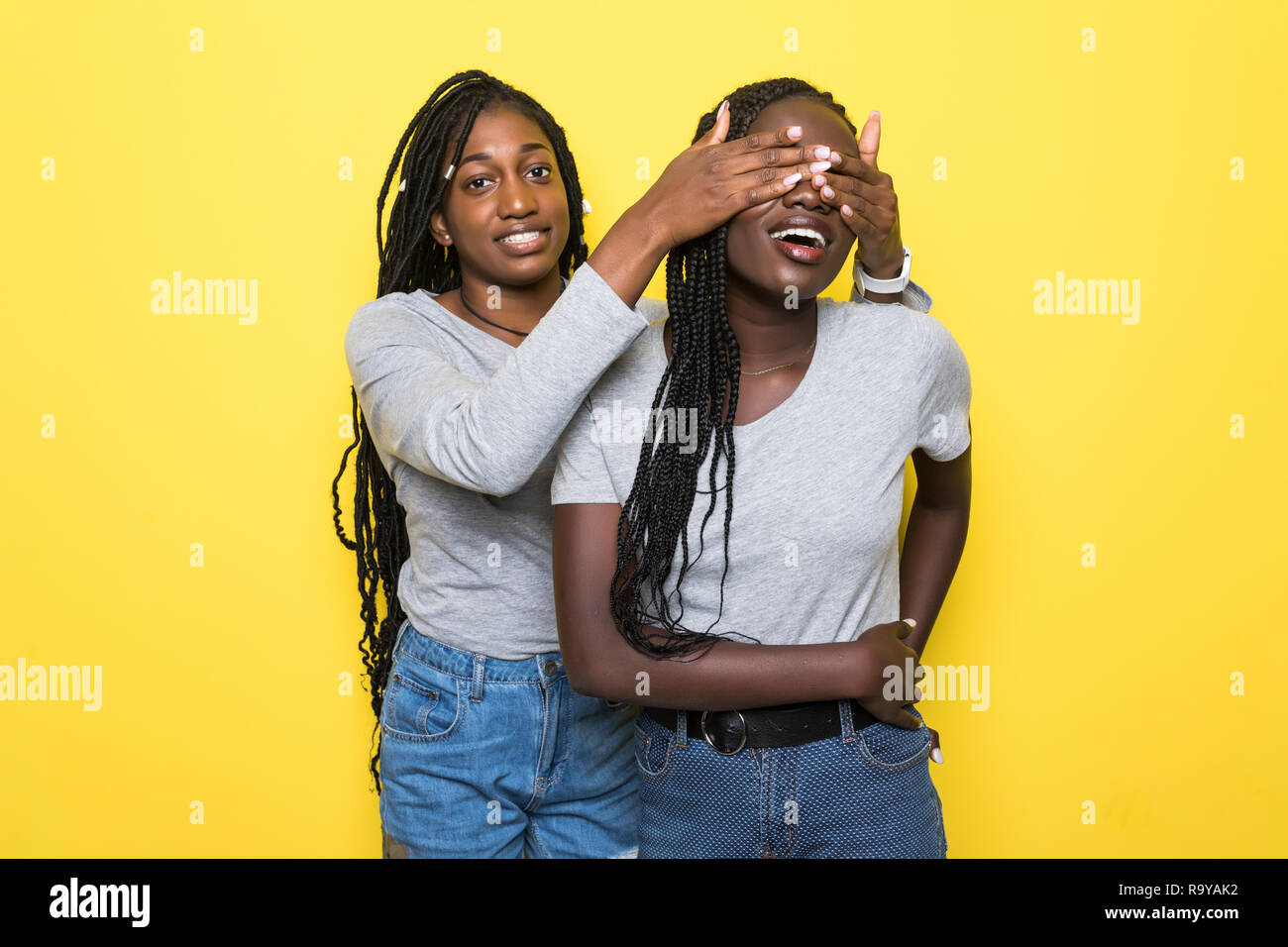 Portrait of two young african women make surprise and cover eyes on ...
