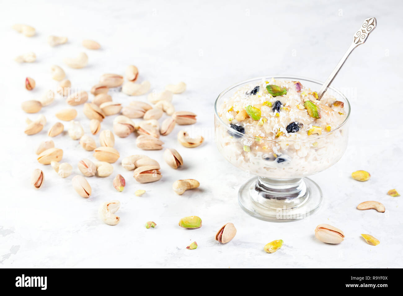 Indian Kheer sweet dessert from rice, nuts and spices in ice cream bowl on white marble table Stock Photo