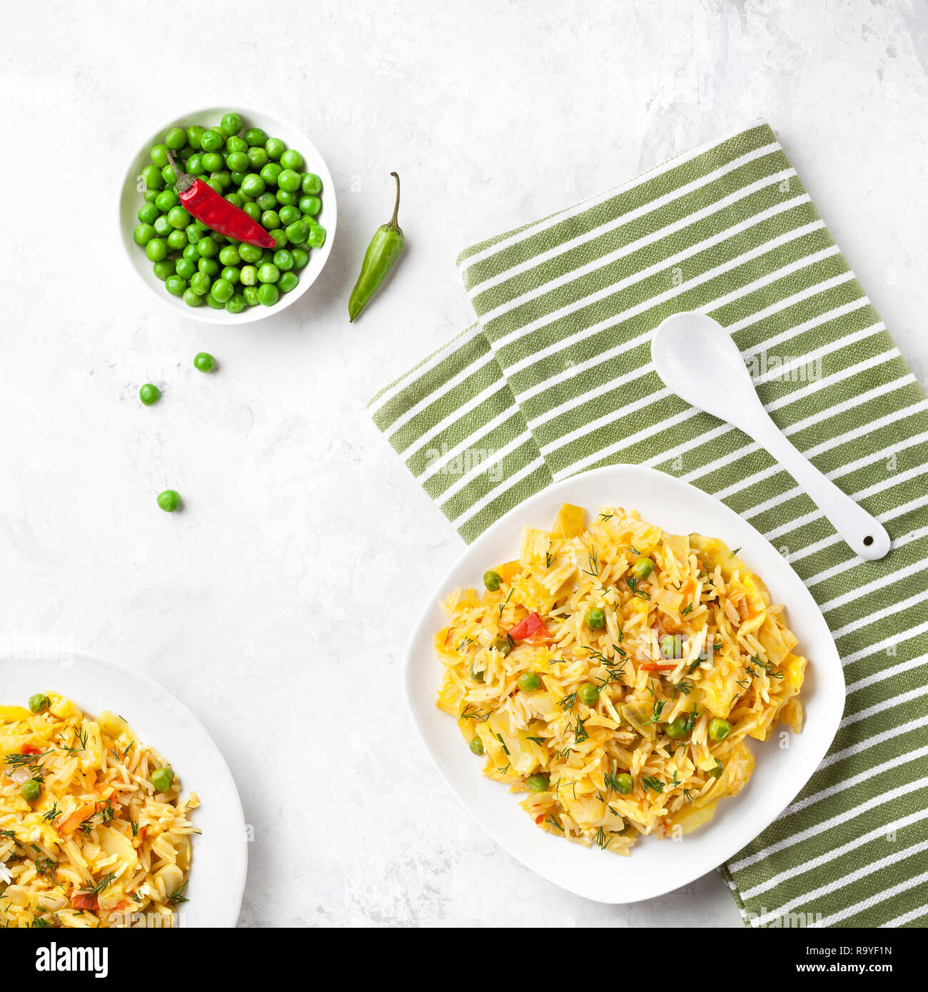 Indian Sabji with rice, vegetables, chili and peas on white table in restaurant Stock Photo
