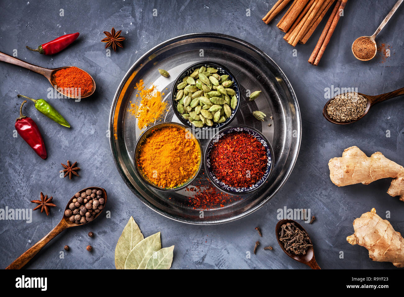 Various Spices like turmeric, cardamom, chili, bayberry, bay leaf, paprika, ginger, cinnamon, cumin, star anise and clove on grunge background Stock Photo