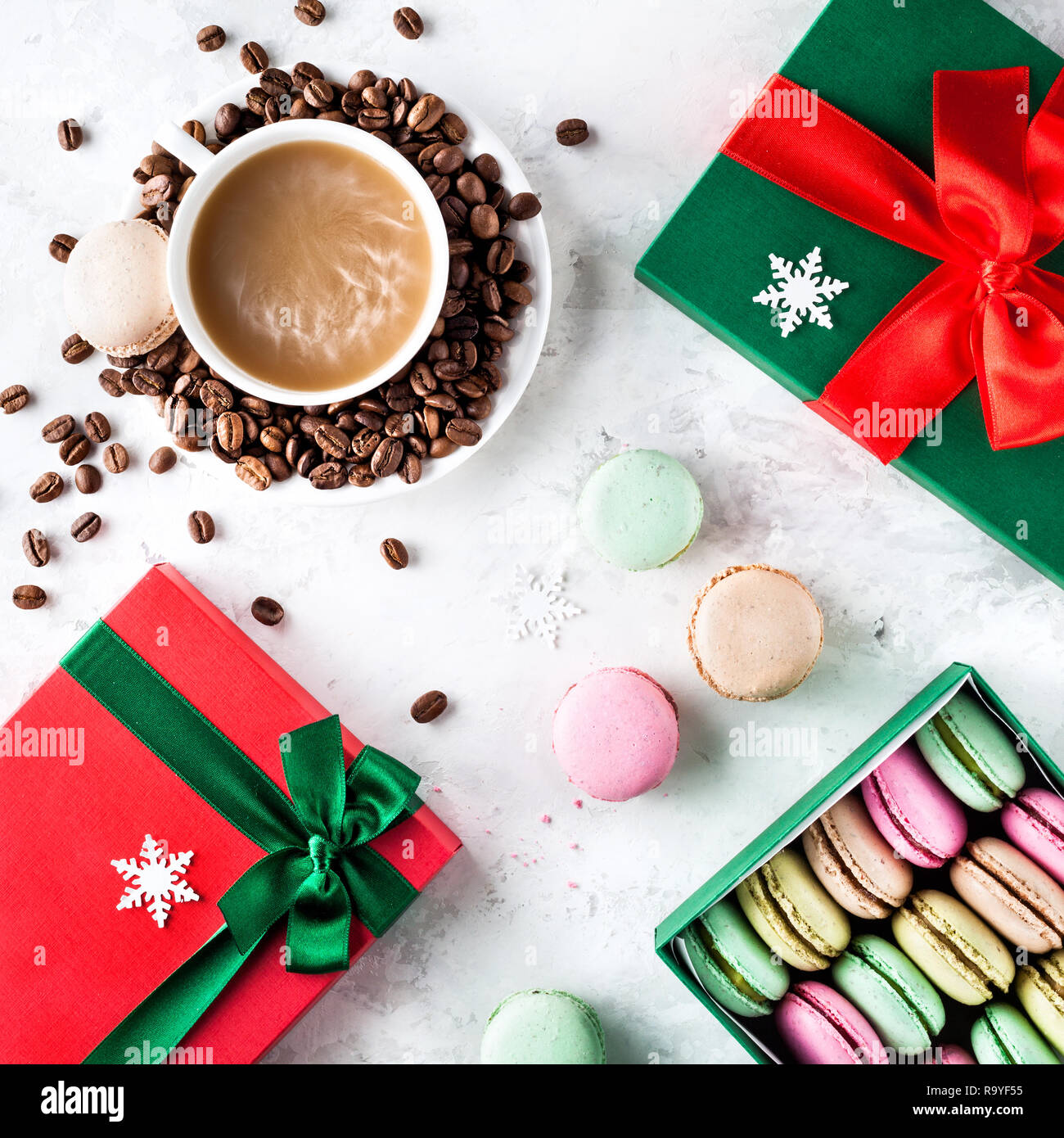 Colorful French macarons with cup of coffee and present Christmas boxes on white background Stock Photo