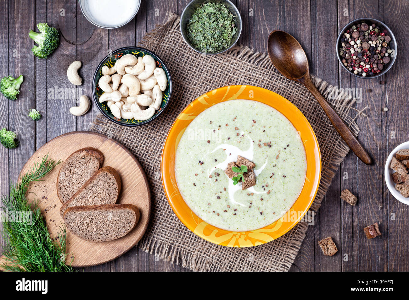 Vegan cream soup with broccoli, fenugreek and cashew nuts on wooden background Stock Photo