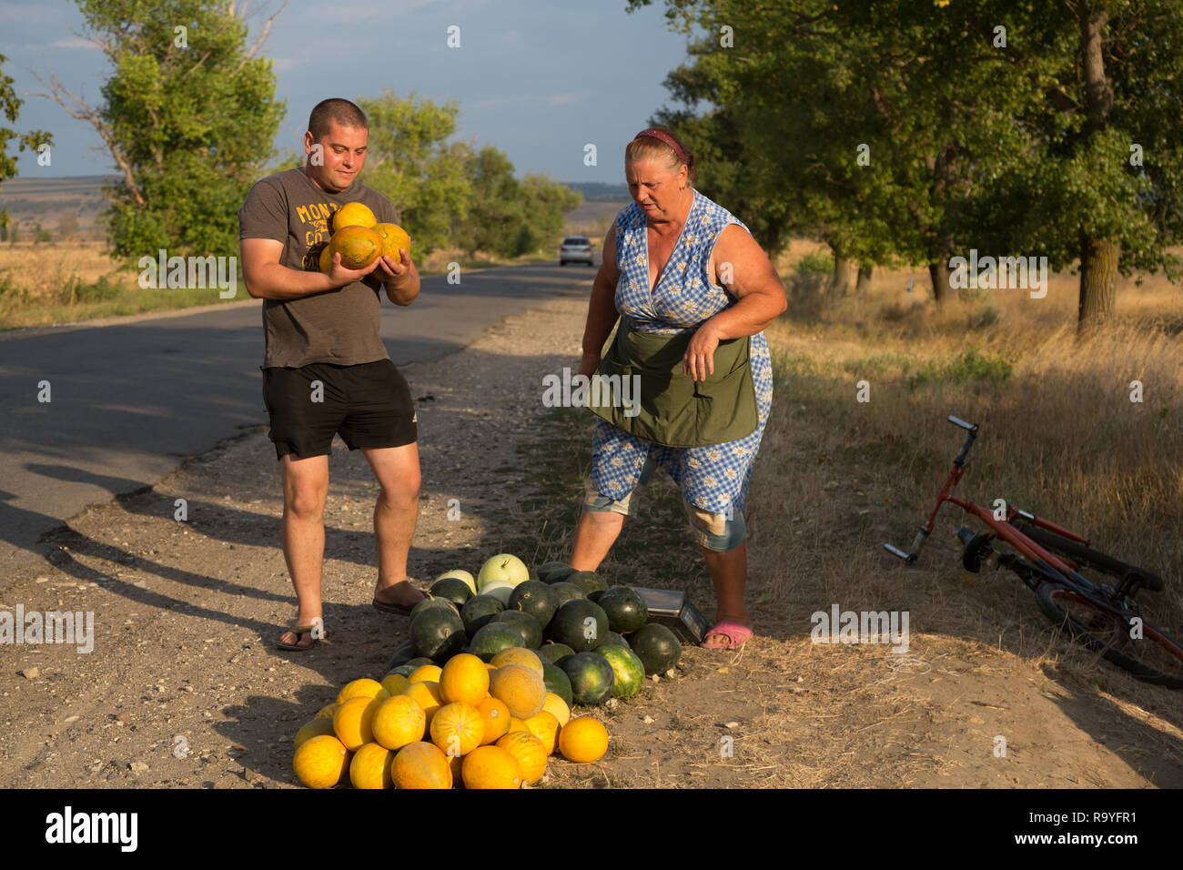 30.08.2016, Causeni, Rajon Causeni, Republik Moldau - Baeuerin verkauft Melonen an der Landstrasse. 00A160830D457CARO.JPG [MODEL RELEASE: NO, PROPERTY Stock Photo