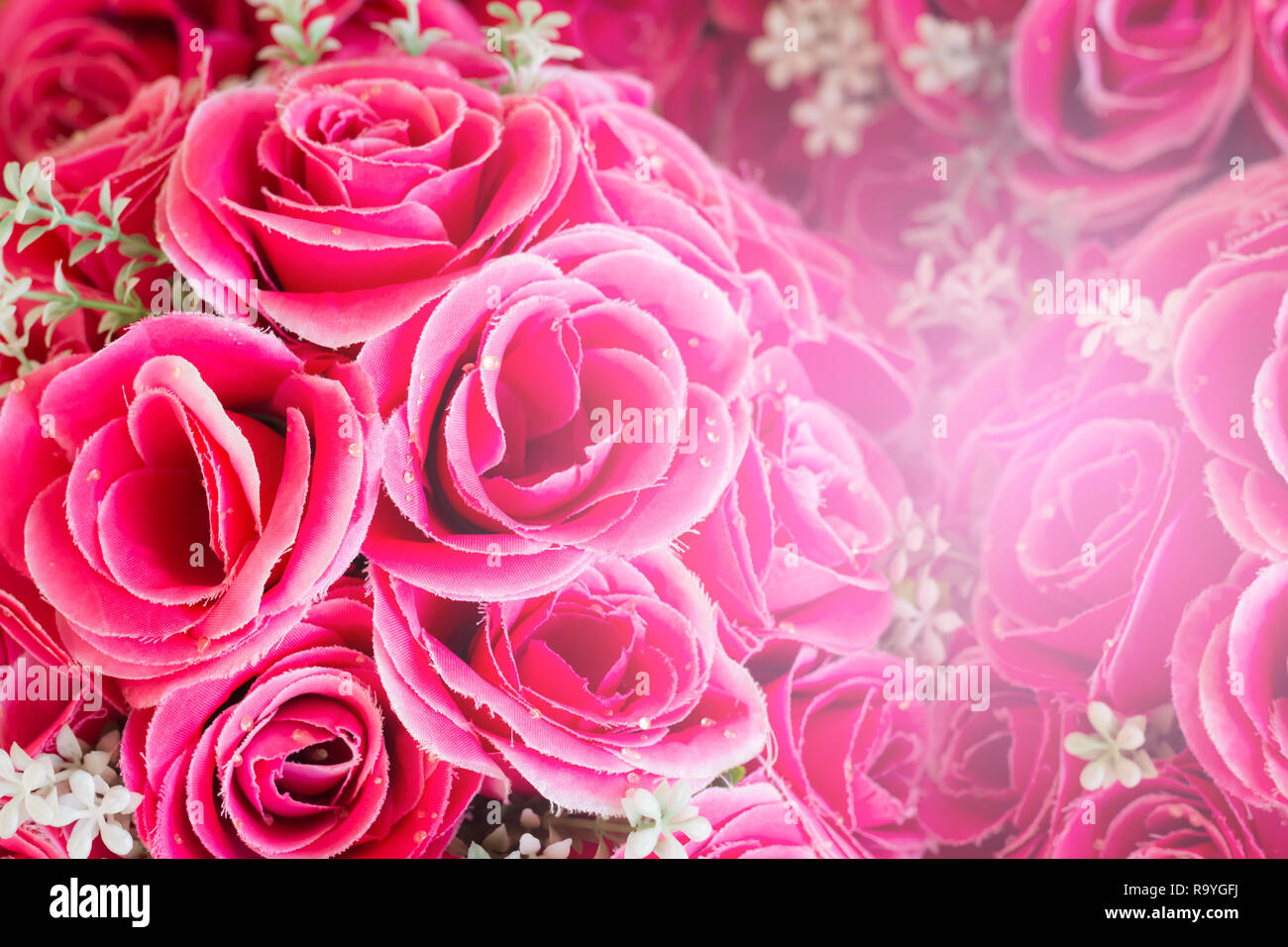 Pink floral background. Lot of artificial roses in colorful ...