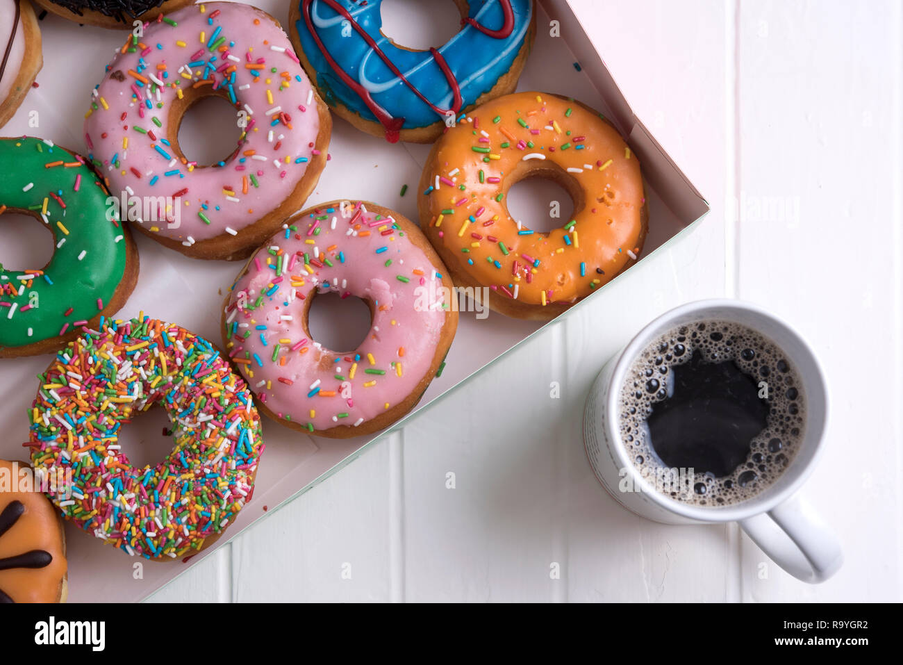 Colorful Donuts with Coffee in White Backdrop Stock Photo