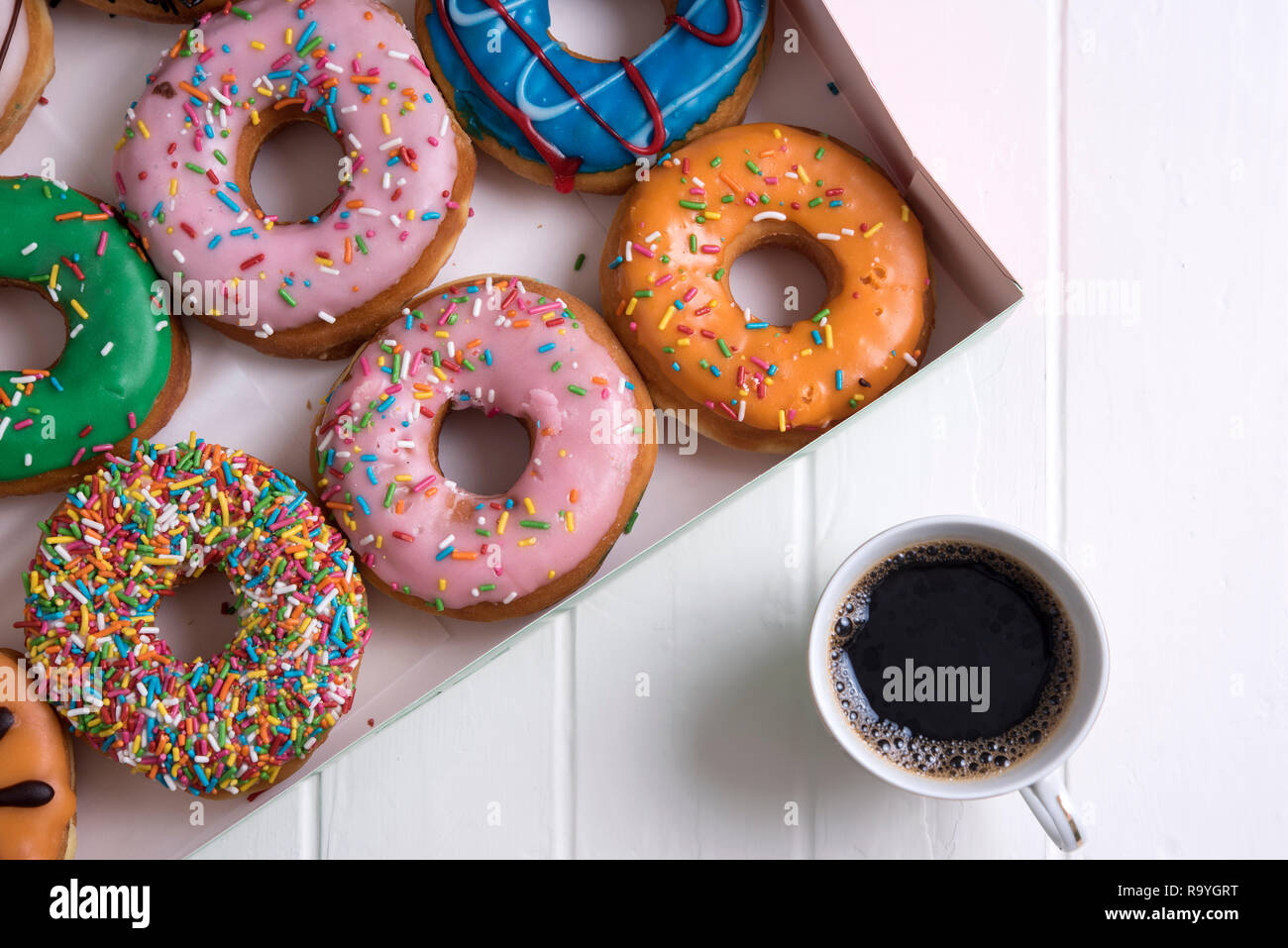 Colorful Donuts with Coffee in White Backdrop Stock Photo