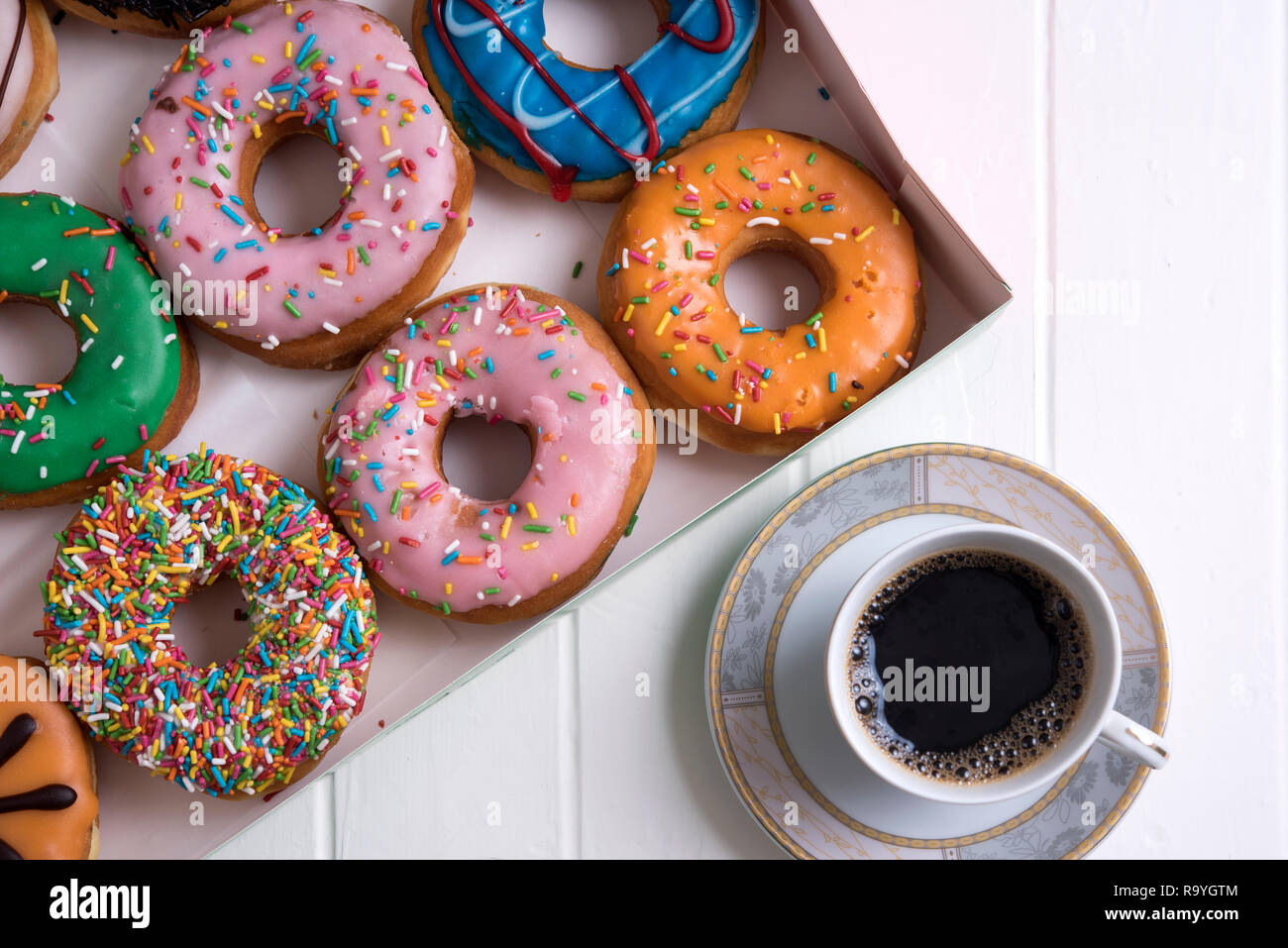 Colorful Donuts with Coffee in White Backdrop Stock Photo