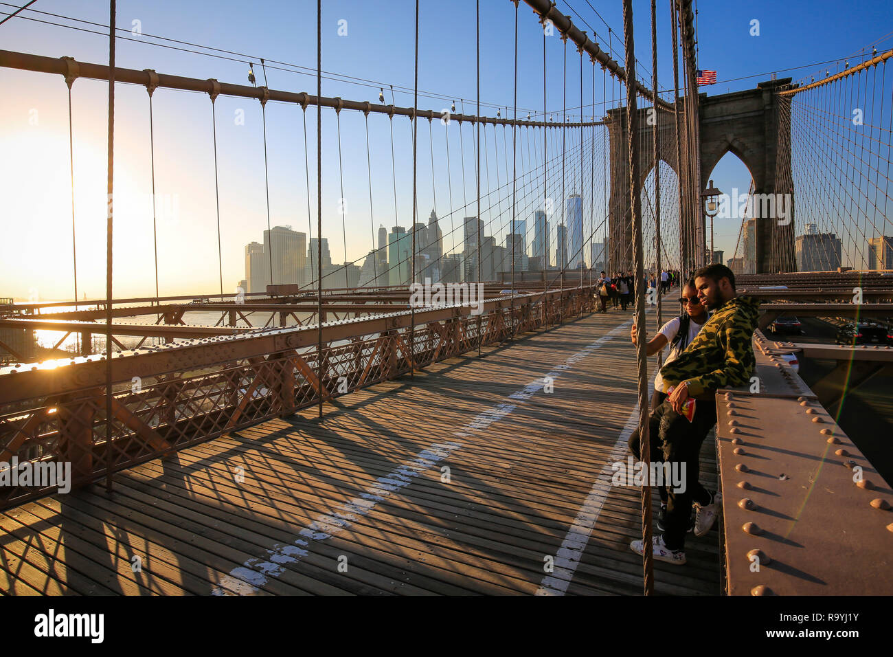 21.02.2018, New York City, New York, Vereinigte Staaten von Amerika - Menschen auf der Brooklyn Bridge, Blick auf die Manhattan Skyline mit Freedom To Stock Photo