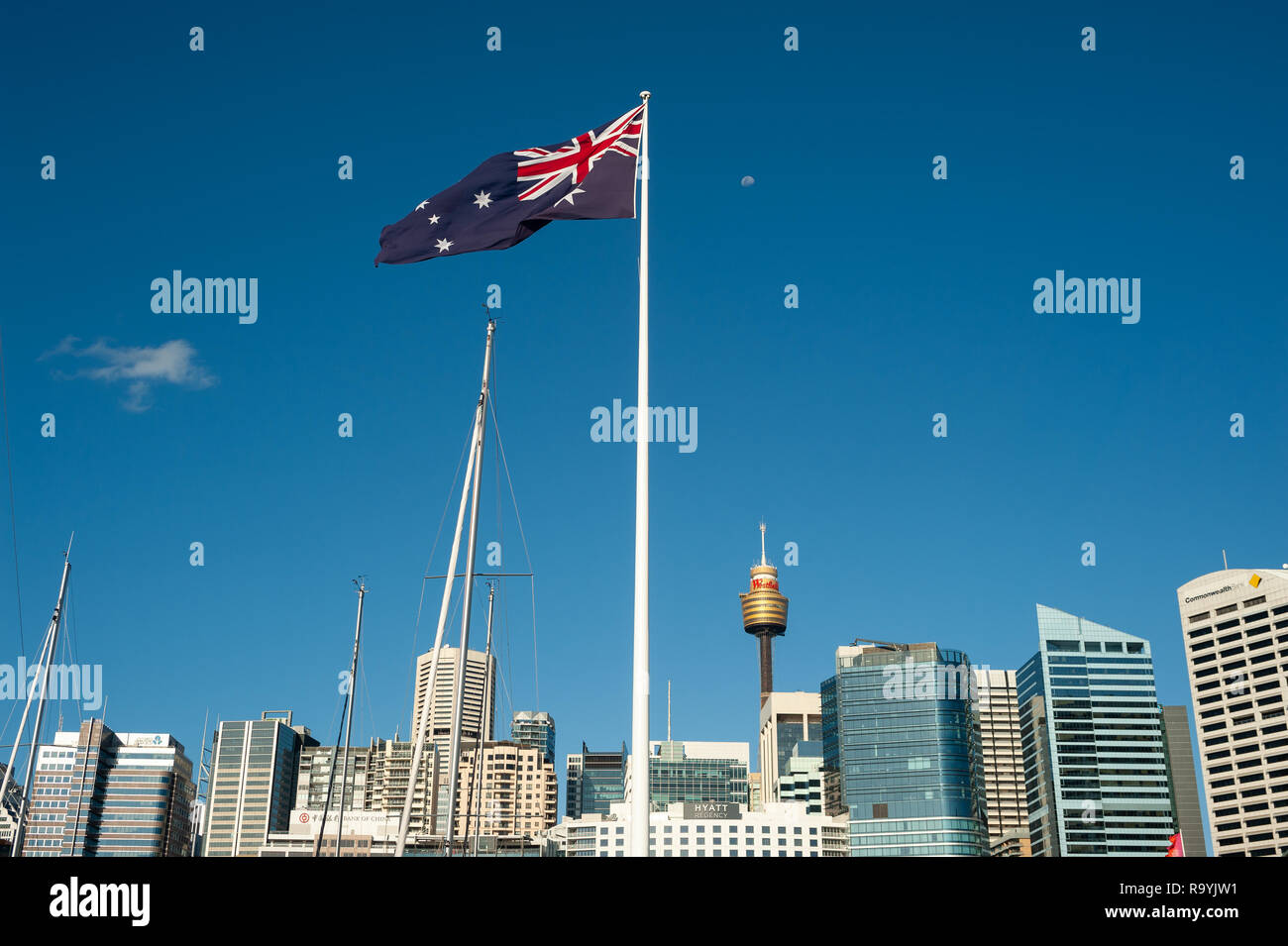 20.09.2018, Sydney, New South Wales, Australien - Eine riesige australische Flagge weht ueber dem Hafen von Darling Harbour mit der Skyline des Gescha Stock Photo