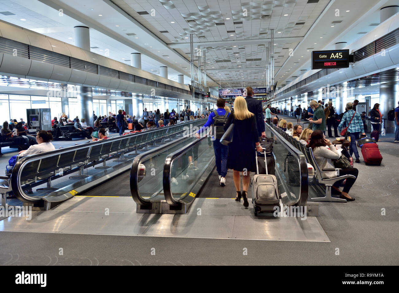 Passengers on moving walkway connecting buildings at Denver International Airport, Colorado Stock Photo