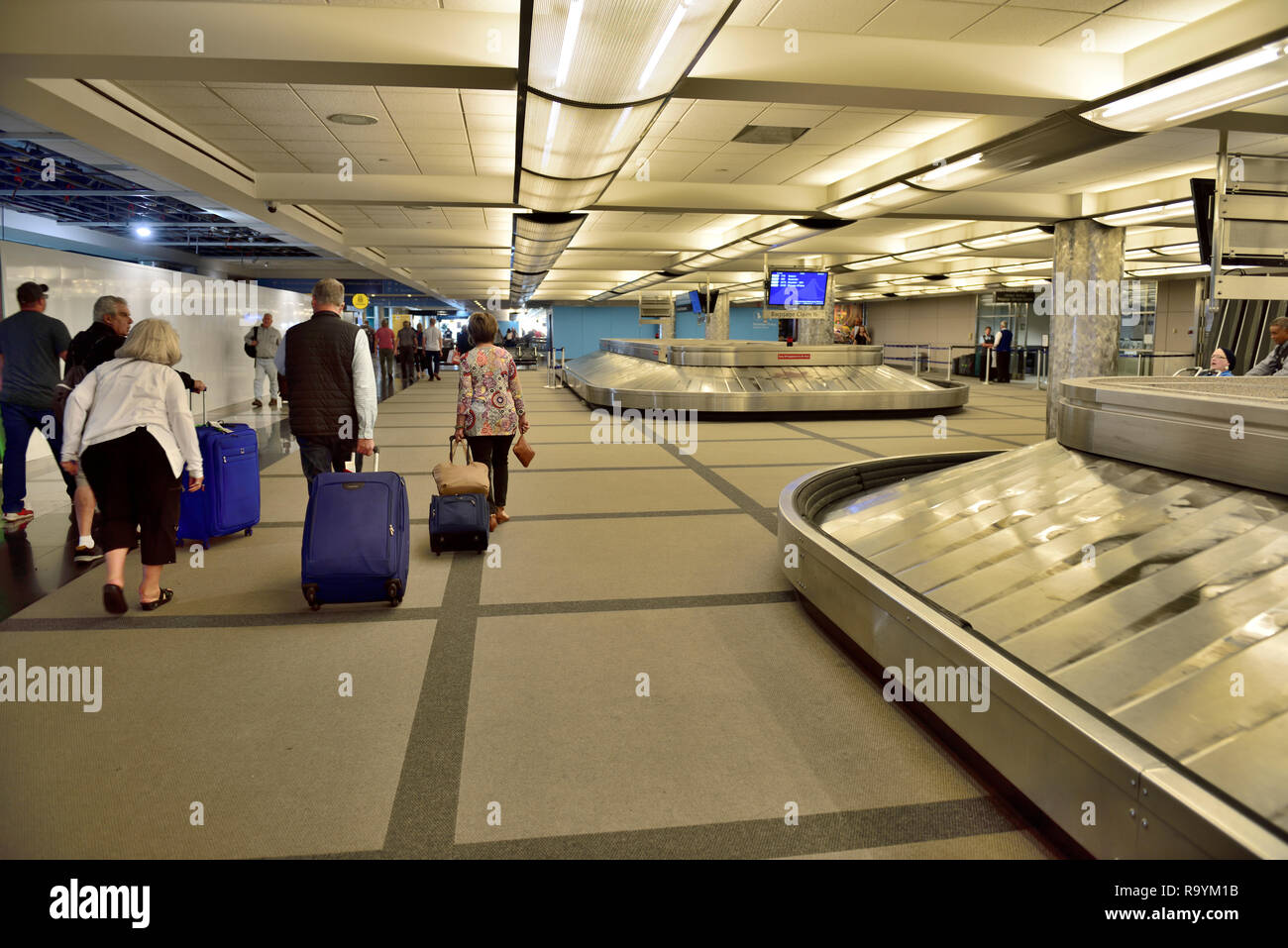 Passengers waling through baggage claim area Denver International Airport terminal, Colorado Stock Photo